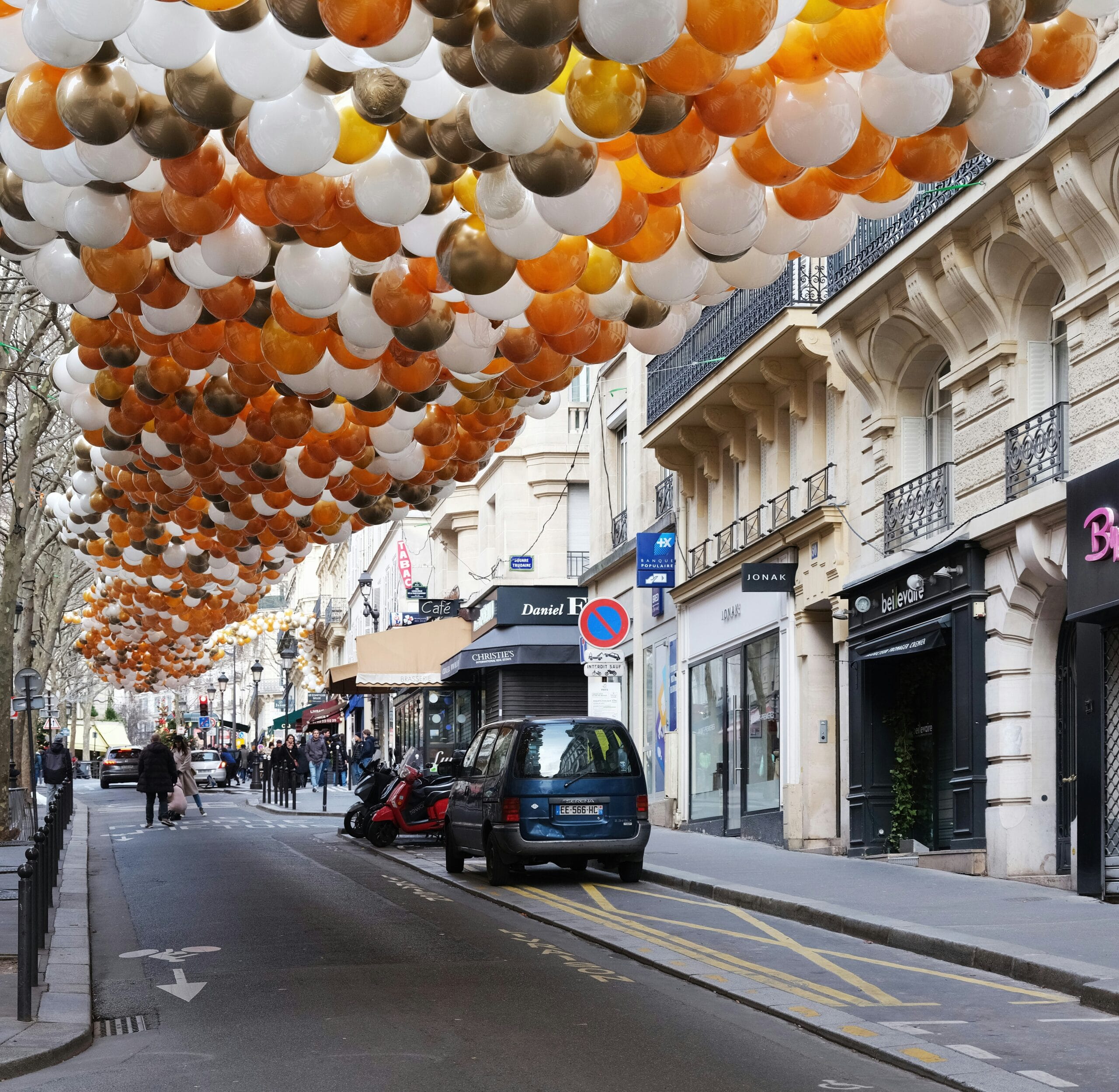 a street filled with lots of balloons hanging from the ceiling